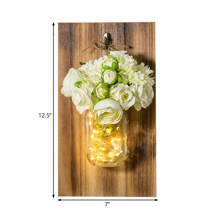 Skørter | Modern white rose string lamp with clear glass container and wooden back panel