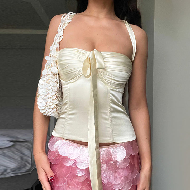 Women's satin top with playful ruffle detail and decorative tie band