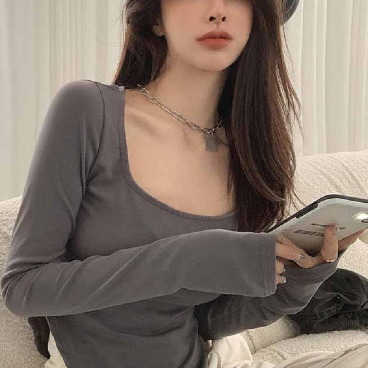 Women's long sleeve top with deep neckline and fitted silhouette